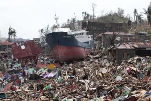 A ship lies on top of damaged homes after it was washed …