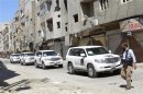 Free Syrian Army fighter passes by convoy of U.N. vehicles carrying a team of U.N. chemical weapons experts at site of alleged chemical weapons attack in Damascus' suburbs of Zamalka