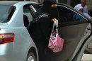 A Saudi woman gets out of a car after being given a ride by her driver in Riyadh, on May 26, 2011