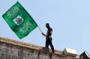 A Palestinian man waves the green flag of the Islamist movement Hamas during a demonstration in Jerusalem on July 3, 2015