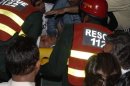 Rescue workers carry injured politician Imran Khan after falling from makeshift elevator during election campaign rally in Lahore