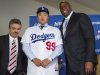 Los Angeles Dodgers general manager Ned Colletti, left, and co-owner Magic Johnson, right, present pitcher Ryu Hyun-jin, center, of South Korea, during a baseball news conference announcing his $36 million, six-year contract, Monday, Dec. 10, 2012, in Los Angeles. Ryu becomes the first player to go directly from the Korea Baseball Organization to the United States big leagues. (AP Photo/Damian Dovarganes)