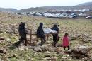 FILE - In this Monday, Jan. 12, 2015 file photo, Iraqis from the Yazidi minority carry a bed frame on Mount Sinjar in northern Iraq, some 400 kilometers (250 miles) northwest of Baghdad. Kurdish military officials in northern Iraq said, Sunday, Jan. 18, 2015, that at least 200 people from the minority Yazidi group have been released from captivity by the Islamic State group. Peshmerga Gen. Shirko Fatih, commander of Kurdish forces in the northern city of Kirkuk, told The Associated Press on Sunday that almost all of the freed prisoners are elderly men and women in poor health. (AP Photo/Seivan Selim, File)