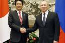 Russia's President Putin and Japan's PM Abe shake hands before their talks in Beijing