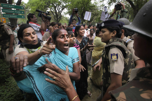 Indian women activists of India's main opposition Bharatiya Janata Party jostle with Indian police women outside ruling United Progressive Alliance chairperson Sonia Gandhi’s residence during a protest against the rape of a 5-year-old girl in New Delhi, India, Sunday, April 21, 2013. The girl was raped and tortured by a man who held her in a locked room in India's capital for two days. (AP Photo/Manish Swarup)