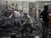 FILE- In this Friday, March 23, 2012, file photo, Indian laborers load coal onto trucks at a coal depot on the outskirts of Jammu, India. India's national auditor said Friday, Aug. 17, 2012, the government lost huge sums of money by selling coal fields to private companies without competitive bidding, adding to massive losses from dubious auctions of other state assets. The Comptroller and Auditor General’s report to Parliament estimated that private companies got a windfall profit of $34 billion because of the low prices they paid for the fields. (AP Photo/Channi Anand, File)