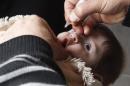 A health worker administers polio vaccination to a child in Raqqa, eastern Syria