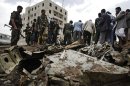 A plane wreck are seen on the ground as security forces and soldiers gather at the site of a plane crash in Sanaa, Yemen, Monday 13, 2013. A Yemeni military plane on a training exercise crashed Monday in the country's capital, slamming into a residential neighborhood and setting at least four houses ablaze. (AP Photo/Hani Mohammed)