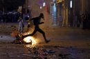 A protester jumps over a fire as he runs from riot police on a street near Taksim Square in Istanbul