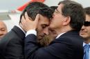 Turkish PM Davutoglu kisses Turkish Consul General of Mosul Yilmaz on the forehead during a welcoming ceremony at Esenboga airport in Ankara