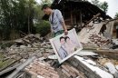 A man recovers his wedding photo from the wreckage of his house after Saturday's earthquake in Longmen township of Lushan county