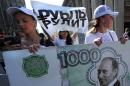 Members of a pro-Vladimir Putin group at a rally in Moscow on August 17, 2011 carry an imitation banknote with a picture of Putin