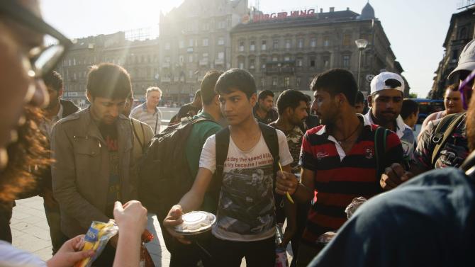FILE - In this Thursday, July 2, 2015 file photo migrants receive food and beverage from members of a Facebook organized group at the Keleti Railway Station in Budapest, Hungary. The U.N. refugee agency says in an open letter published on Friday, July 4, 2015, changes to Hungary&#39;s asylum system being rushed through parliament and the government&#39;s plan to build a fence on the border with Serbia could have &quot;fatal consequences&quot; for refugees fleeing war. (Zoltan Balogh/MTI via AP)