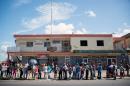 Venezuelans queue outside a supermarket to buy basic food and household items, after massive lootings took place in Ciudad Bolivar, on December 19, 2016