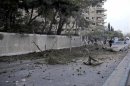 Debris and damaged vehicles are pictured on a street after a car bomb exploded in Damascus