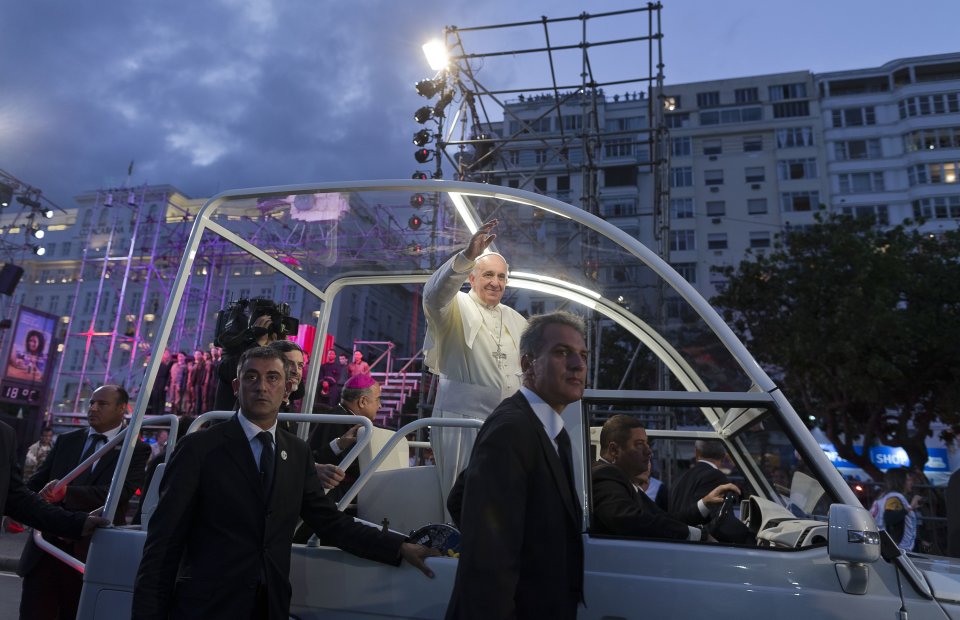 Pope Francis waves from his popemobile as he arrives for the Stations of the Cross event on Copacabana beach in Rio de Janeiro, Brazil, Friday, July 26, 2013. Also known as the Via Crucis and Via Dolorosa, the Stations of the Cross are built around reflections on Jesus' last steps leading up to his crucifixion and death. Francis started off the day, his fifth in Rio, by hearing confessions from a half-dozen young pilgrims in a park and met privately with juvenile detainees.. (AP Photo/Domenico Stinellis)