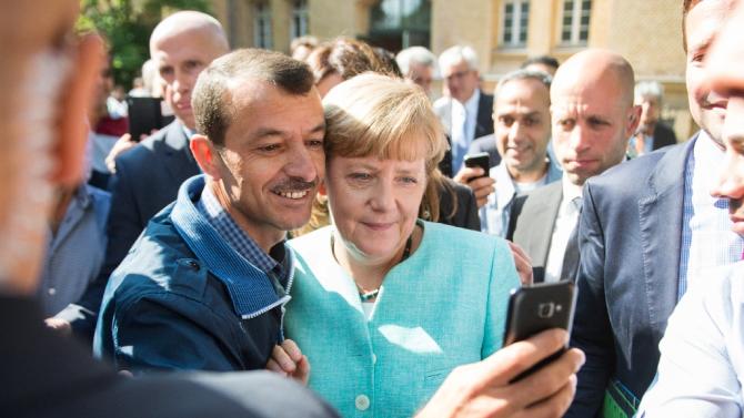 German Chancellor Angela Merkel takes a &quot;selfie&quot; with an asylum-seeker at the Federal Office for Migration and Refugees in Berlin