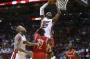 LeBron James, del Heat de Miami, salta para encestar frente a Dwight Howard, de los Rockets de Houston, en el partido del domingo 16 de marzo de 2014 (AP Foto/J Pat Carter)