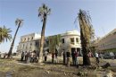 People stand near a Libyan Foreign Ministry building in Benghazi after an explosion in Benghazi