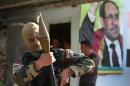An Iraqi Shiite Turkmen gunman holds his RPG as he stands in front of a portrait of Iraqi Prime Minister Nouri al-Maliki, right, at the front line village of Taza Khormato, in the northern oil rich province of Kirkuk, Iraq, Friday June 20, 2014. Thousands of people fled the town of Taza Khormato fearing the advance of Sunni insurgents who overran the neighboring village of Kirkuk. Taza Khormato residents said insurgents led by the al-Qaida inspired Islamic State in Iraq and the Levant seized the nearby village of Basheer, shelling and burning down the houses. Both communities are dominated by ethnic Turkmen Shiites who are seen as heretics worthy of death by Sunni extremists. (AP Photo/Hussein Malla)