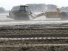 In this May 22, 2012, photo, heavy equipment is used to move sand in a farm field in Missouri Valley, Iowa. Hundreds of farmers in Iowa and Nebraska are still struggling to remove sand and fill holes gouged by the Missouri River, which swelled last summer with rain and snowmelt and overflowed onto thousands of acres of farmland. (AP Photo/Charlie Neibergall)