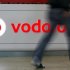 A customer walks past the Vodafone logo in a shopping mall in Prague