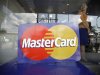 An employee stands behind a MasterCard logo during the launch of the international credit card issuer's first ATM transaction in Myanmar, in Yangon