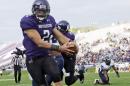 FILE - In this Sept. 21, 2013, file photo, Northwestern quarterback Kain Colter (2), wears APU for "All Players United" on wrist tape as he scores a touchdown during an NCAA college football game against Maine in Evanston, Ill. The five-member regulatory board that will ultimately decide if Northwestern University football players can unionize has itself been in the middle of a firestorm. The very makeup of the National Labor Relations Board has been challenged in a case now before the Supreme Court. And Republicans contend the agency has being overly friendly to organized labor. (AP Photo/Nam Y. Huh, File)