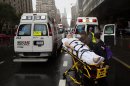A patient is wheeled to an ambulance in the rain during an evacuation of New York University Tisch Medical, Tuesday, Oct. 30, 2012, in New York. Sandy, the storm which was downgraded from a hurricane just before making landfall, caused multiple fatalities, halted mass transit and cut power to more than 6 million homes and businesses (AP Photo/ John Minchillo)