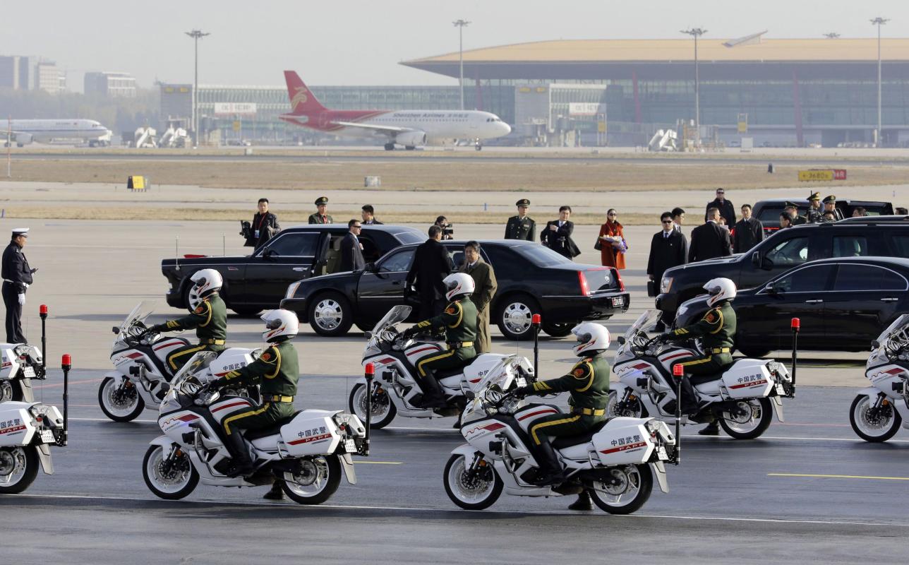 Chinese paramilitary policemen ride motorcycles as they convoy U.S. President Barack Obama&#39;s limousine after his arrival in Beijing