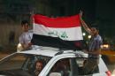 Iraq football fans celebrate in a car in Baghdad after the Iraqi national football team won its Asian Cup 2015 qualifier against China on March 5, 2014