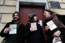 Greenpeace activists (L-R) Briton Iain Rogers, Gizem Akhan from Turkey, and Anne Mie Roer Jensen of Denmark, show their Russian transit visas outside of the Federal Migration Service Department in St Petersburg, on December 26, 2013