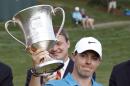 Rory McIlroy, of Northern Ireland, raises the trophy after winning the Wells Fargo Championship golf tournament at Quail Hollow Club in Charlotte, N.C., Sunday, May 17, 2015. (AP Photo/Bob Leverone)