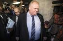 Ford walks through a busy media scrum as he walks to his office during a break in a Capital and Operating Budgets meeting at City Hall in Toronto