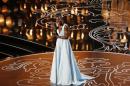 Nyong'o, best supporting actress winner for her role in "12 Years a Slave", racts on stage at the 86th Academy Awards in Hollywood