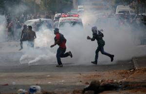 Palestinian protesters run through tear gas in clashes &hellip;