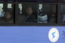 South Koreans look out a bus window upon their arrival from the North Korean city of Kaesong at the customs, immigration and quarantine office near the border village of Panmunjom, which has separated the two Koreas since the Korean War, Tuesday, April 9, 2013. A few hundred South Korean managers, some wandering among quiet assembly lines, were all that remained Tuesday at the massive industrial park run by the rival Koreas after North Korea pulled its more than 50,000 workers from the complex. Others stuffed their cars full of goods before heading south across the Demilitarized Zone that divides the nations. (AP Photo/Lee Jin-man)