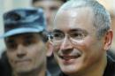 A file picture on June 3, 2011, shows former tycoon Mikhail Khodorkovsky being being escorted to a courtroom in Moscow
