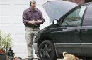 Everett Dutschke works on his mini-van in his driveway in Tupelo