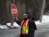 A crossing guard helps students at an intersection after schools closed early ahead of bad weather in Pelham, New York