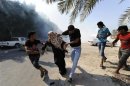 Anti-government protesters run from tear gas fired by riot police as they attempt to get to the village of Diraz