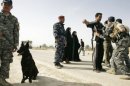 Iraqi police commandos frisk people in Baquba in 2010