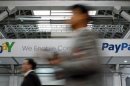 Visitors walk past an Ebay and PayPal banner at the Mobile World Congress in Barcelona