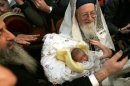 A rabbi carries an eigh-day-old baby during a circumcision ceremony