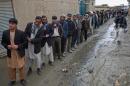 Afghan men line up for the registration process before they cast their votes at a polling station in Kabul, Afghanistan, Saturday, April 5, 2014. Afghans flocked to polling stations nationwide on Saturday, defying a threat of violence by the Taliban to cast ballots in what promises to be the nation's first democratic transfer of power. The vote will decide who will replace President Hamid Karzai, who is barred constitutionally from seeking a third term. (AP Photo/Massoud Hossaini)