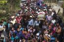 Thousands accompany the coffins containing the remains of two children, who were kidnapped and then killed over the weekend when family could not raise the ransom money, in a funeral procession in Ajuix, Guatemala, Tuesday, Feb. 14, 2017. Authorities found the bodies of the two boys, aged 10 and 11, on Sunday, stabbed and thrown into sacks in the municipality of San Juan Sacatepéquez, northwest Guatemala. (AP Photo/Moises Castillo)
