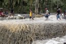 Residents carry the body of victim after flash floods brought by Typhoon Bopha swept New Bataan town in Compostela Valley in southern Philippines