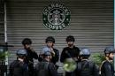Police commandos stand guard outside the damaged Starbucks coffee shop in central Jakarta on January 16, 2016