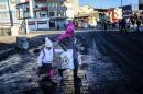 A woman walks with a child on December 22, 2015 during security operations against Kurdish rebels in the southeastern Turkey cities of Cizre and Silopi