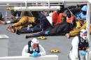 Survivors of the smuggler's boat that overturned off the coasts of Libya lie on the deck of the Italian Coast Guard ship Bruno Gregoretti, in Valletta's Grand Harbour, Monday, April 20 2015. A smuggler's boat crammed with hundreds of people overturned off Libya's coast on Saturday as rescuers approached, causing what could be the Mediterranean's deadliest known migrant tragedy and intensifying pressure on the European Union Sunday to finally meet demands for decisive action. So far rescuers saved 28 people a recovered 24 bodies. (AP Photo/Lino Azzopardi)